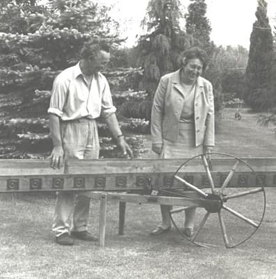 A black and white photo of Henry and Madge Jackson behind a an artifact.