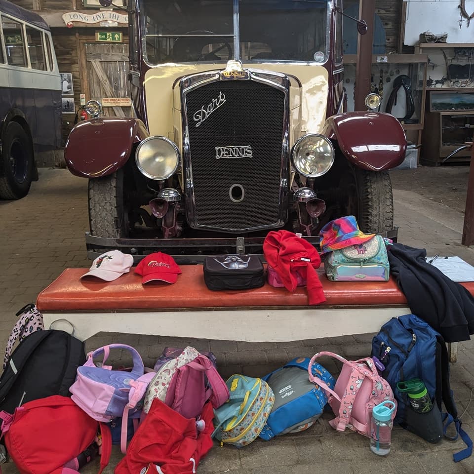 A photo of a tractor with lots of different colour backpacks around it.